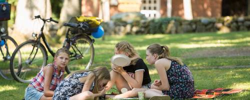 Kinder sitzen auf einer Wiese