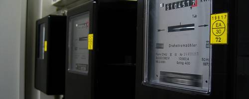 Drei Stromzähler an einer Wand.