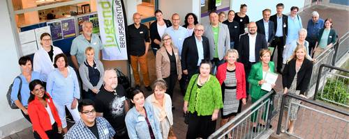 Eine große Gruppe von Personen steht vor dem Eingang der Jugendberufsagentur.