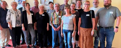 Eine Gruppe Menschen steht in einer Reihe nebeneinander.