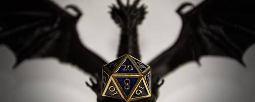 Im Vordergrund liegt ein Würfel, im Hintergrund ist der Schatten eines Drachen.