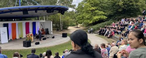 Rückansicht vieler Menschen, die in einem Amphitheater