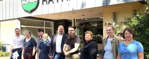 Eine Gruppe Männer und Frauen stehen vor dem Rathaus der Stadt Laatzen