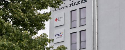 Außenaufnahme eines weiß verputzten Gebäudes mit einem Schild der Leine-VHS