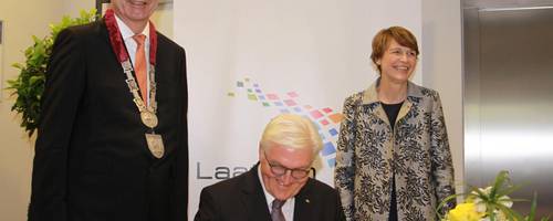 Steinmeier bei der Unterschrift, neben ihm seine Frau Elke Büdenbender und Bürgermeister Jürgen Köhne