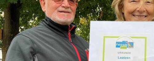 Eine Frau und ein Mann halten eine Urkunde.