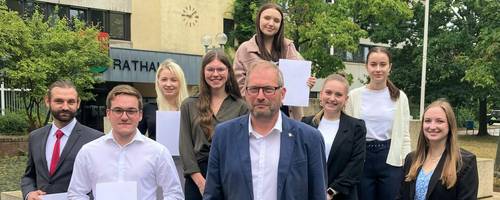 Neun Menschen stehen vor dem Rathaus Laatzen.