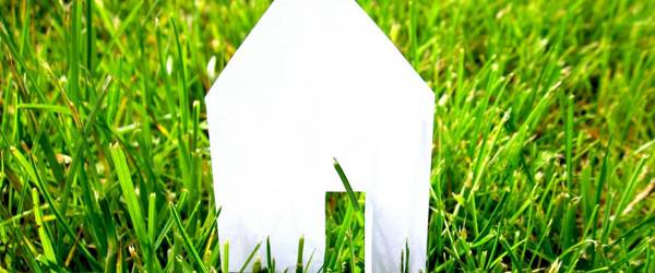 Häusersilhouette aus Papier auf grünem Rasen ©Pixabay