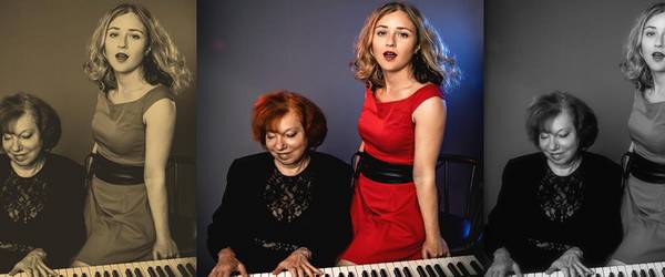 Links auf dem Bild sitzt  eine schwarz gekleidete Frau am Klavier, neben ihr steht die Sängerin im roten Kleid.