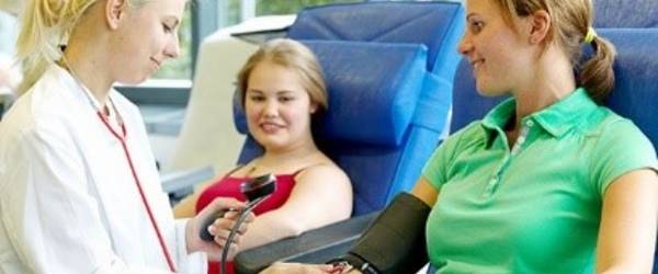 Ärztin misst vorbereitend Blutdruck bei einer Patientin