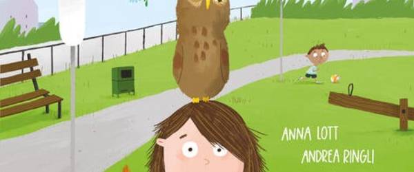 Ein Kind steht mit einer Eule auf dem Kopf und weiteren Tieren an ihrem Körper im Park