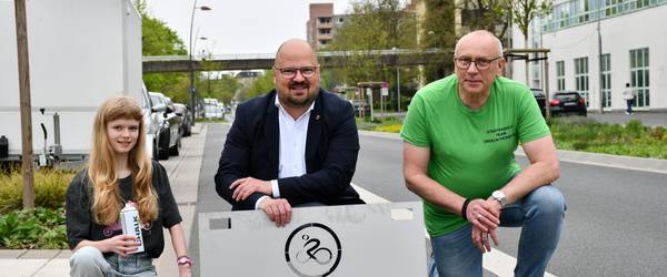 Werbebild mit zwei Männern und einem Mädchen und einem STADTRADEL Schild.