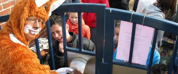 Mann im Hasenkostüm öffent das Tor zum Park der Sinne