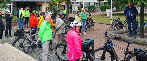 Eine Gruppe Radfahrer versammelt sich vor dem Rathaus.