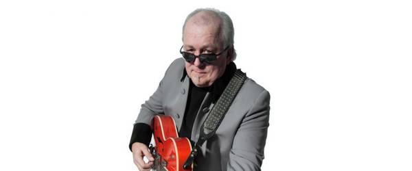 Ein Mann mit Sonnenbrille spielt auf einer Gitarre.