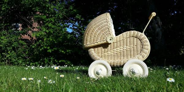 nostalgischer Puppenwagen auf einer grünen Wiese