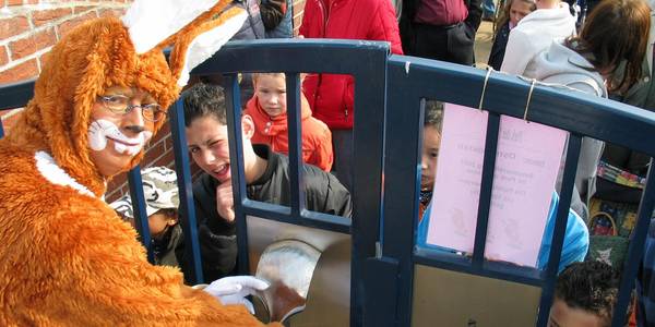 Mann im Hasenkostüm öffent das Tor zum Park der Sinne